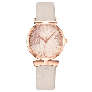 Women's quartz watch with beige leaf pattern dial, bow charm, and white leather strap