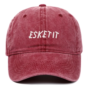 Close-up of white ESKETIT letter embroidery on a washed red cotton baseball cap