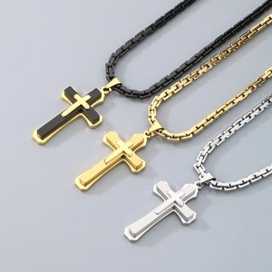 Close-up of triple layered titanium steel cross pendants in gold, silver, and black colors