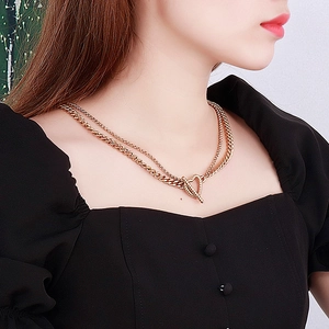 Double-layered golden titanium steel necklace with heart pendant and OT clasp on a model