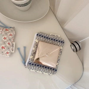 Detail of floral cotton pouches storing a compact mirror with simple wish labels
