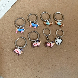 Detail view of 8-piece colorful enamel dachshund puppy hoop earrings on craft paper