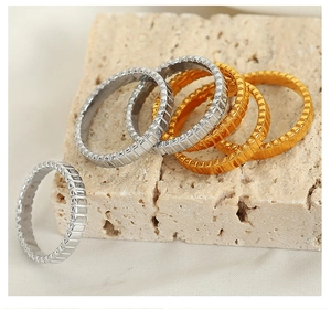 Macro shot of titanium steel gear rings in gold and silver on a stone surface