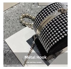 Detail shot of silver metal lobster clasp and shiny rhinestone cylinder bag surface