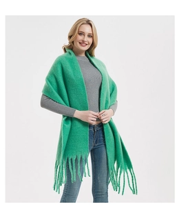 Detail showing the soft texture and long green tassels of the mohair style scarf