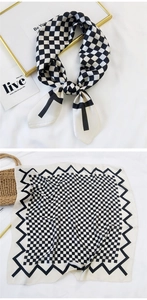 Detail of silk-like scarf with black and white checkerboard pattern and smooth texture