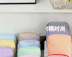 Détail de pochettes en seersucker à rayures colorées empilées dans diverses teintes pastel