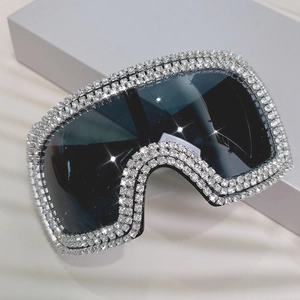 Close-up of oversized punk sunglasses with square rhinestones and black shield lenses