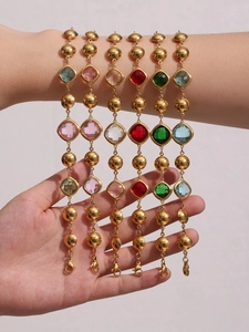 Close-up of 18k gold plated bracelets with colorful square-cut Czech glass stones