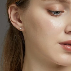 Close-up of minimalist S925 silver stud earring with tiny sparkling zircon on model