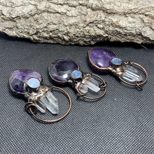 Detail of amethyst heart and white crystal points set in vintage bronze wire pendant