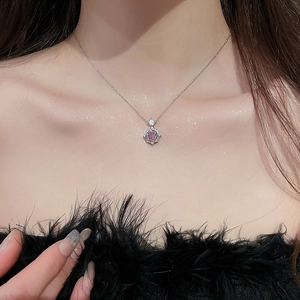 Detail of 14k gold plated necklace with a pink round gemstone and zircon floral pendant