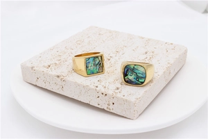 Detailed macro view of gold titanium steel rings with iridescent abalone shell inlays