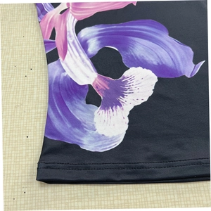 Gros plan détaillé sur l'imprimé floral violet et l'ourlet à double couture