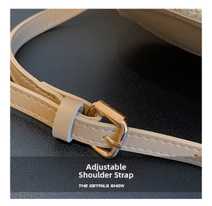 Detalle de la correa ajustable de cuero beige con hebilla dorada en bolso de paja tejida