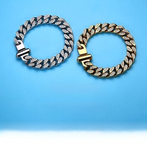 Dettaglio dei bracciali a catena cubana oro e argento con zirconi e chiusura a incastro