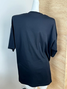 Rear view of oversized black short-sleeve T-shirt with loose silhouette on a mannequin
