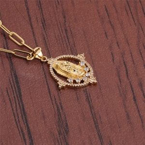 Detail of a gold religious pendant with zircons on a paperclip chain over dark wood