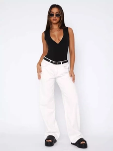Women's minimalist white wide-leg denim jeans styled with black belt and platform sandals