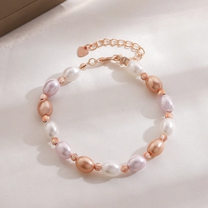 Detail of elegant pearl bracelet featuring starfish charms and a rose gold heart clasp