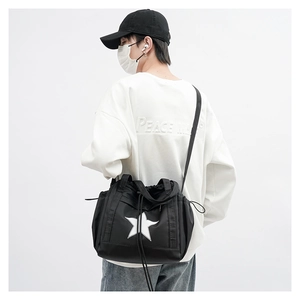 Detail of black nylon crossbody bag featuring a white star logo and adjustable strap