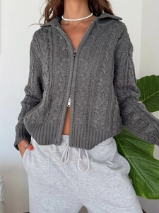 Detail view of grey cable-knit cardigan with front zipper and textured rib cuffs