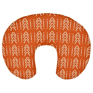 Close-up of terracotta baby nursing pillow cover with white arrow and dot patterns