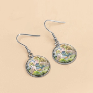 Detailed view of silver hook earrings featuring vintage art glass cabochon pendants