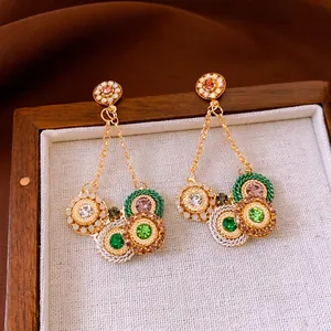 Vintage bohemian drop earrings with colorful rhinestones and woven details on a gold chain