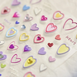 Macro detail of colorful heart nail stickers with glitter and sparkling rhinestones