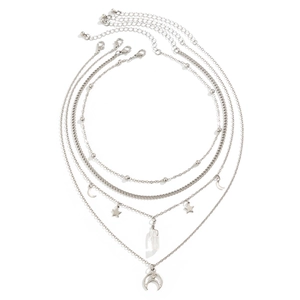 Detail of layered silver necklaces featuring star, moon charms and a teardrop pendant