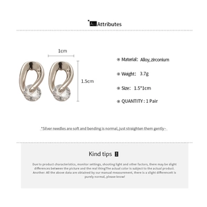 Detail view of twisted silver alloy earrings with cubic zirconia and silver pins