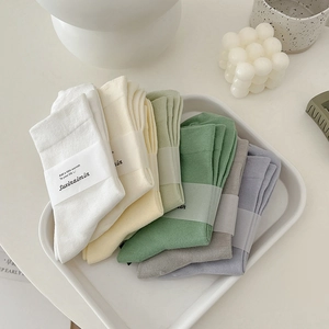 Weiche Baumwoll-Stulpensocken in Morandi-Farben auf einem minimalistischen Tablett