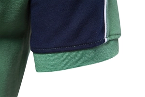 Detail of color-block polo shirt sleeve with navy green pique fabric and ribbed cuff