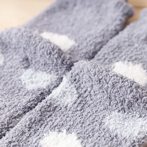 Close-up of soft coral fleece texture on grey socks with white polka dot pattern
