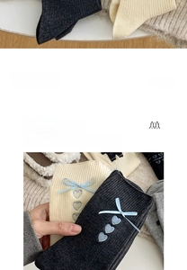Detailansicht grauer Baumwollsocken mit blauen Seidenschleifen und Herzstickerei-Detail