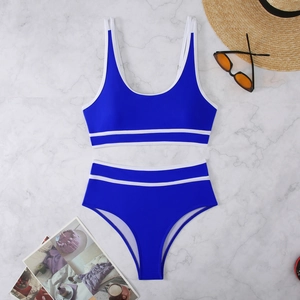 Royal blue two-piece bikini set with white stripes on marble background with summer props