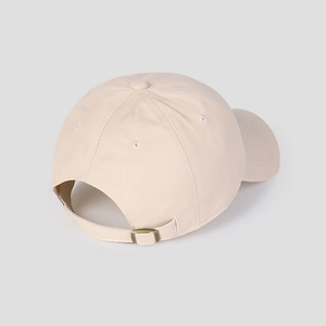 Detail der verstellbaren Metallschnalle und des Stoffes an der beigen Baseballkappe