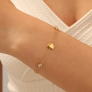 Bracciale a catena con cuore in acciaio dorato e zircone tondo al polso di donna