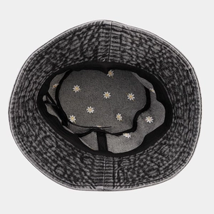 Detailed interior view of denim bucket hat featuring white daisy floral lining