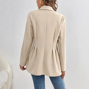 Détail d'un blazer beige élégant montrant des plis au dos et une coupe cintrée soignée