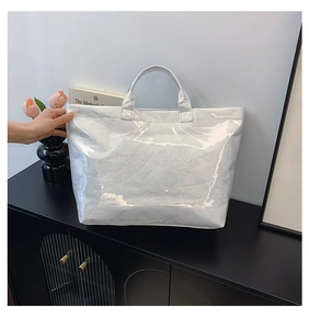 Detail of white Tyvek tote bag with glossy crinkle texture and embossed Tote Bag text