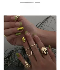 Close-up of assorted gold polished rings on a hand with retro artistic feather background