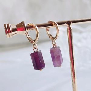 Detail of 14K gold hoop earrings featuring natural purple amethyst gemstone cylinders