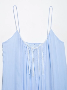 Detail of light blue camisole with delicate white lace trim and crinkled fabric texture