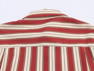 Détail d'une chemise à rayures rouges et beige montrant l'empiècement avec motifs croisés