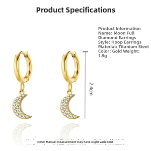 Macro shot of gold-plated titanium moon earrings with white pavé crystal details