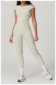 Detail of high-stretch cream yoga set with short sleeve top and high-waisted leggings