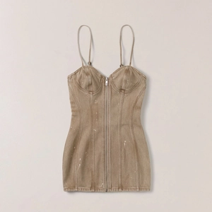 Détail d'une mini robe en jean marron avec taches de peinture blanche et zip frontal