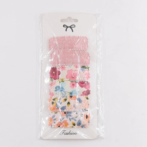 Detailed view of 6-piece floral embroidery and pink lace hair clips set on card